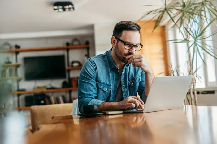 Person mit Laptop am Tisch